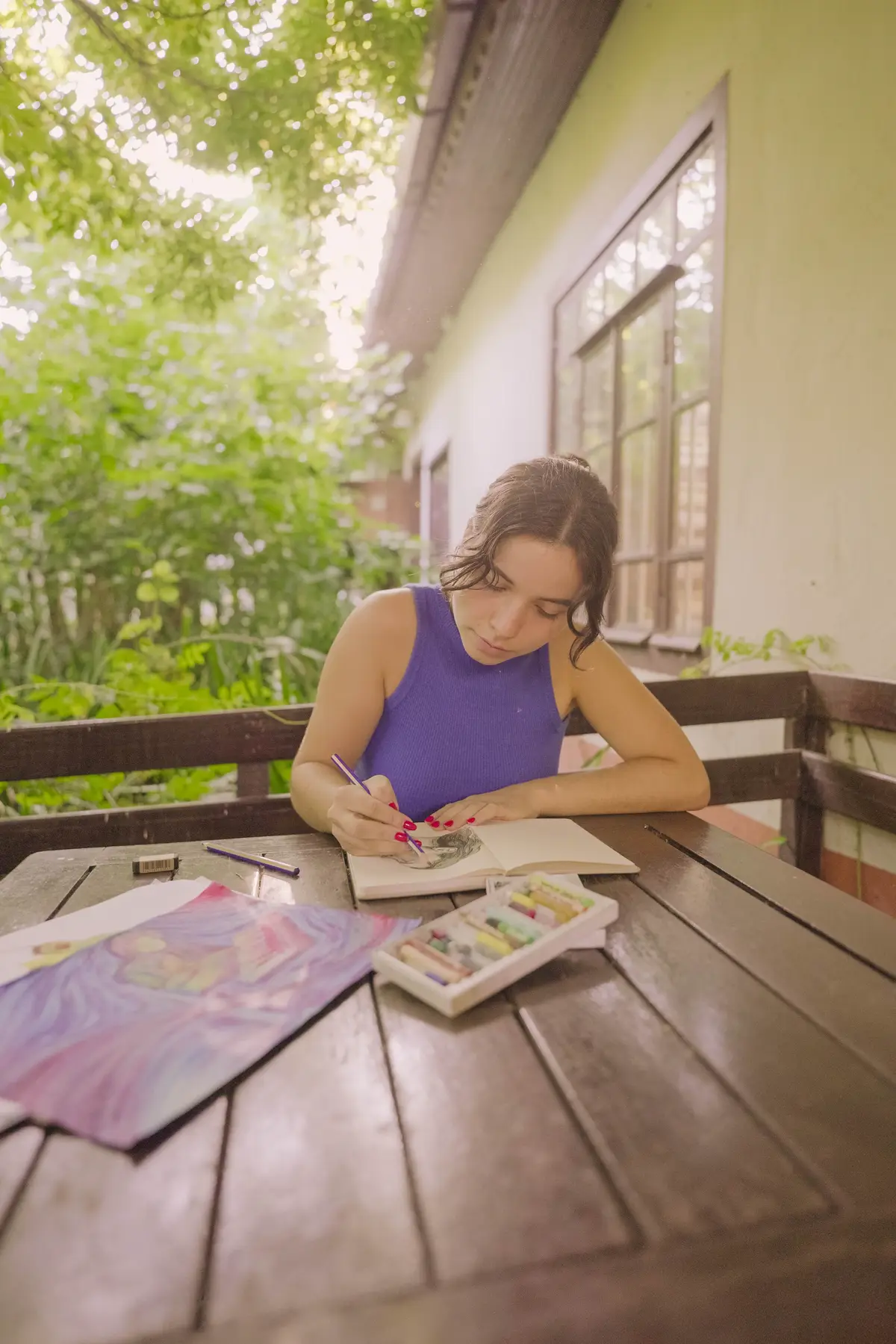 Desainer menggambar dengan pensil warna di meja kayu