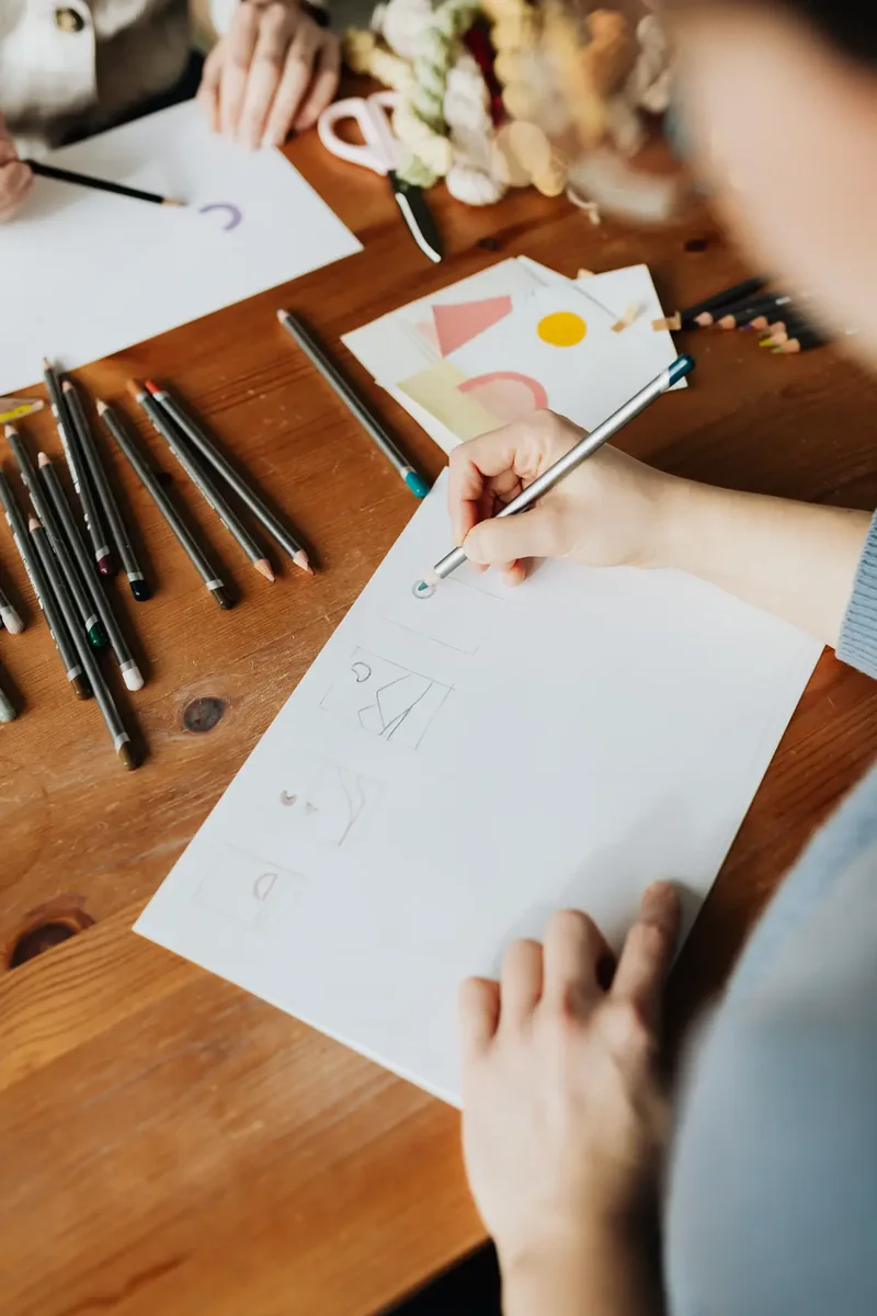Dua desainer membuat sketsa pensil di meja kerja