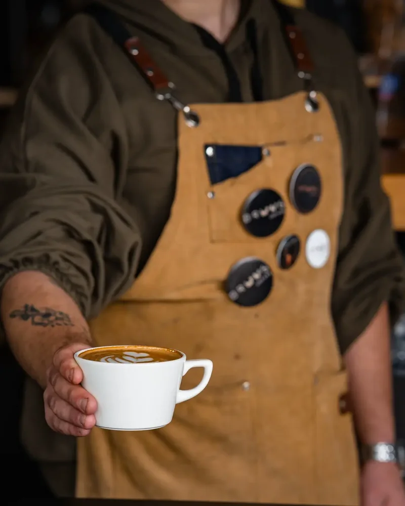 Barista menyajikan latte di kafe