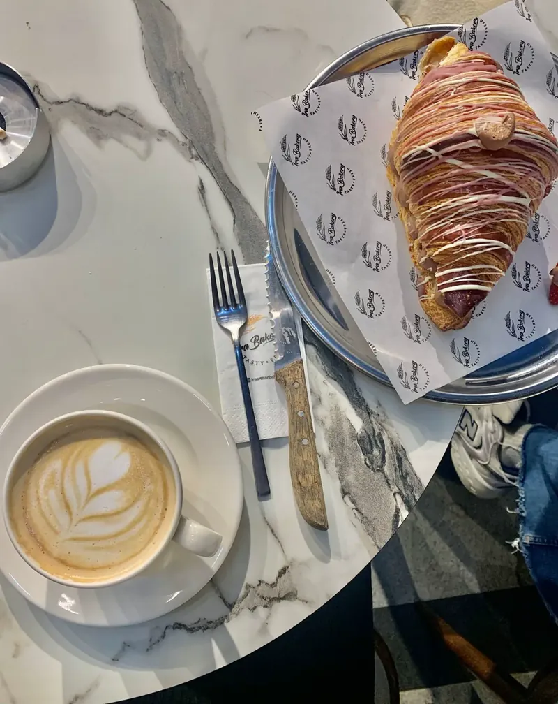Latte dan croissant di meja marmer