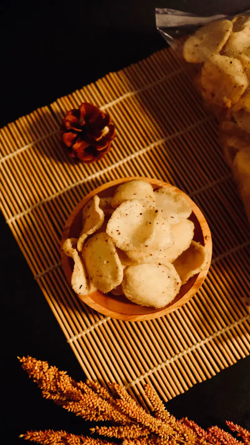 Keripik singkong dan kerupuk dalam mangkuk kayu