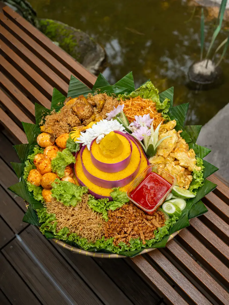 Tumpeng dengan lauk di sekelilingnya