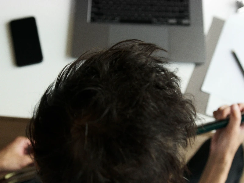 Seseorang dari belakang, duduk di depan laptop