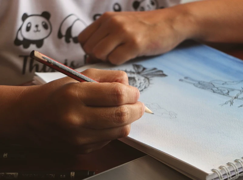 Tangan menggambar sketsa di buku catatan