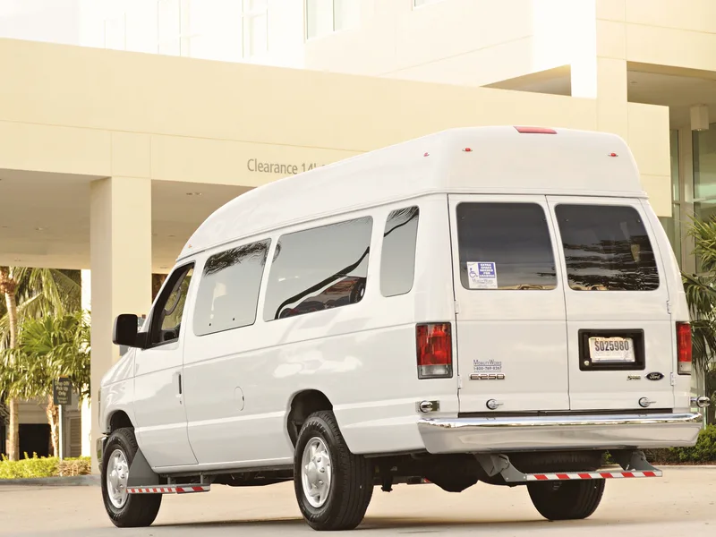 Minibus putih diparkir di depan gedung
