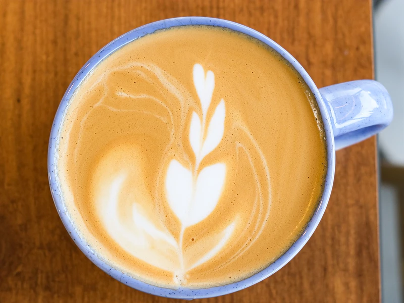 Segelas kopi susu di meja kafe
