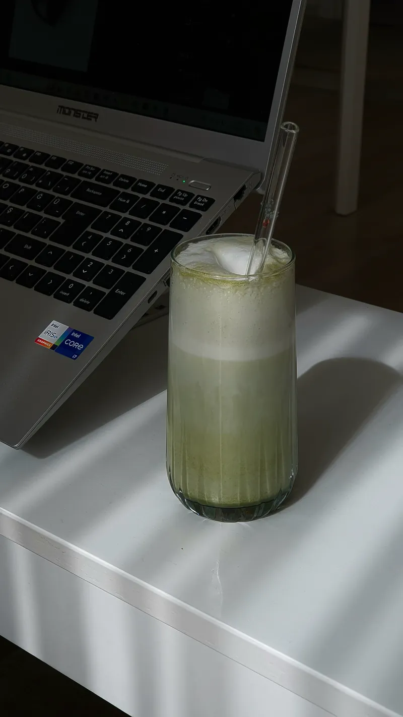 Matcha dingin di samping laptop
