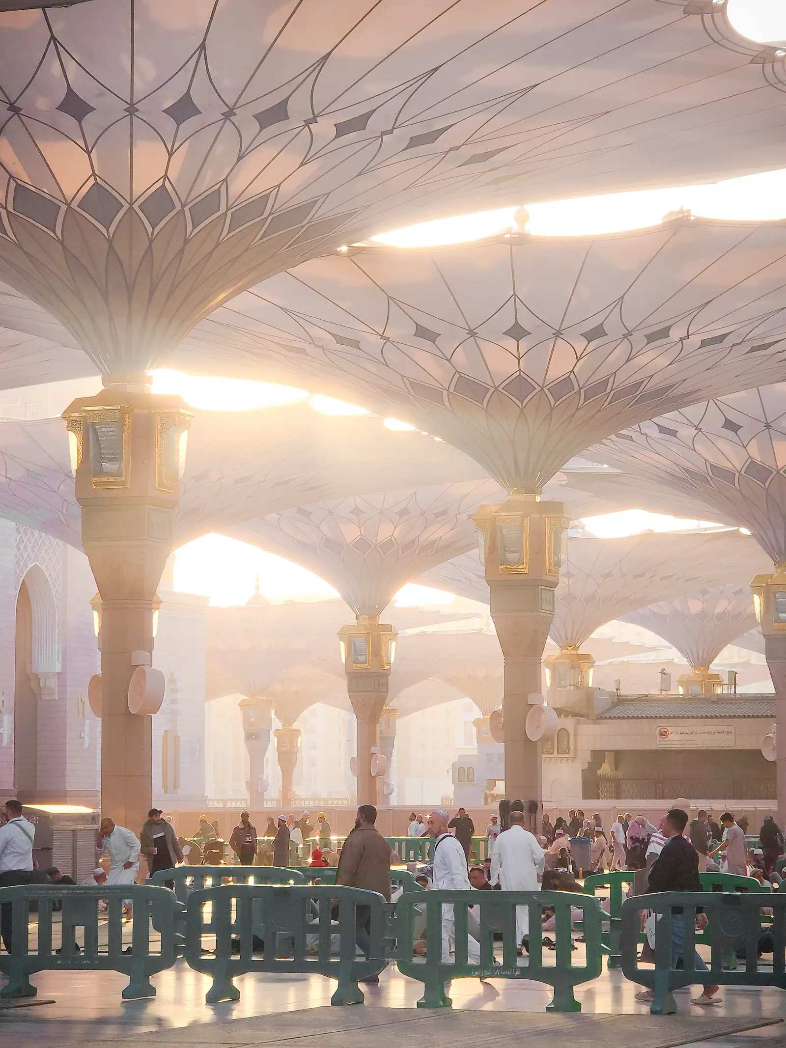 Payung besar di pelataran masjid, orang terlihat dari jauh