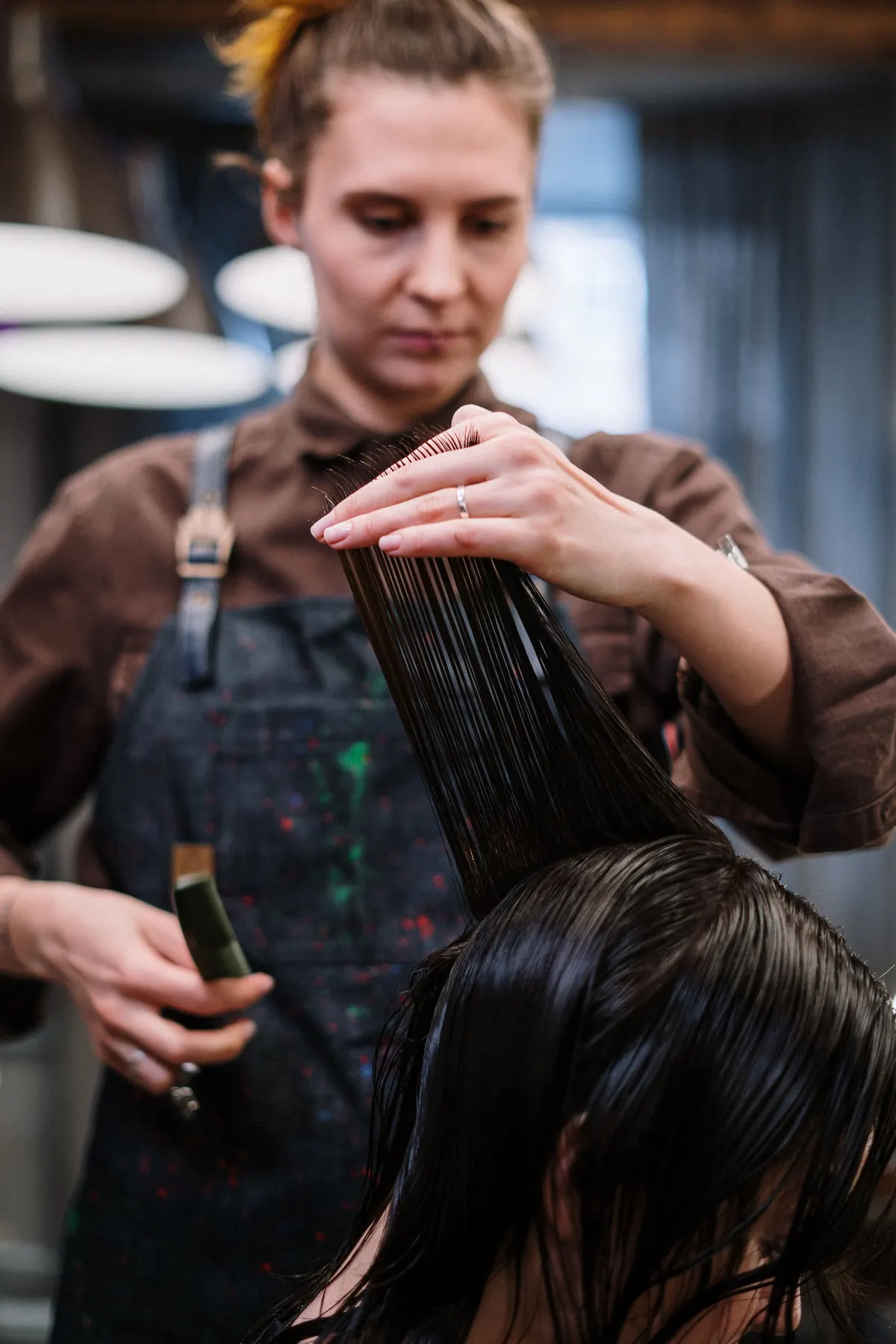 Penata rambut memotong rambut di salon