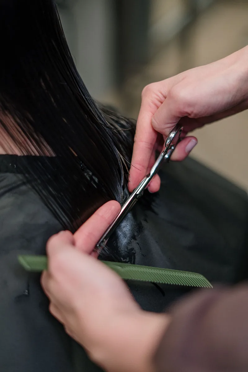 Penata rambut memotong rambut hitam