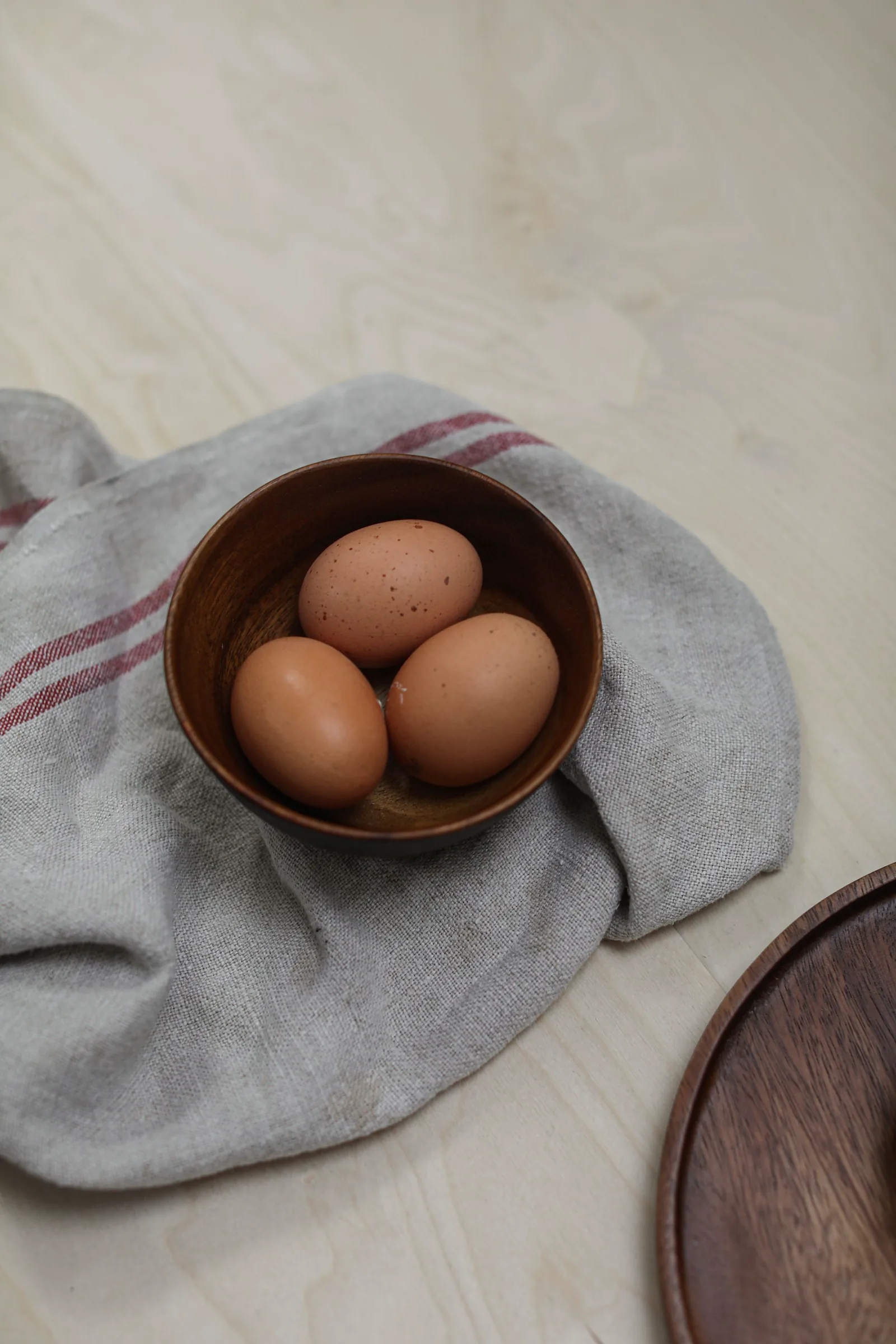 Telur ayam di mangkuk kayu